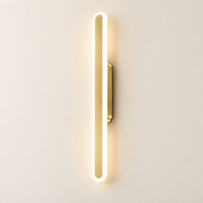 Luma Loop brushed-gold LED wall light illuminated on a warm ivory studio wall