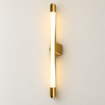 Serein brushed-gold curved LED wall light illuminated on a warm ivory studio wall