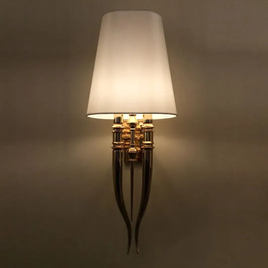 Ivy Trail shaded wall sconce illuminated on a wall