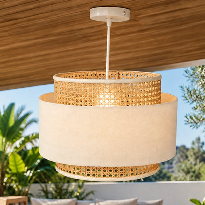 Layered cane and fabric pendant light illuminated on a covered veranda