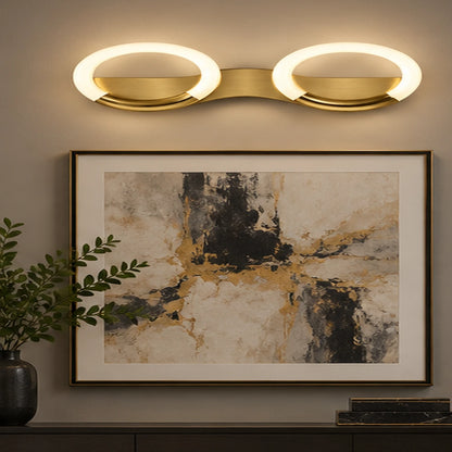 Antique-brass oval-ring wall light above artwork