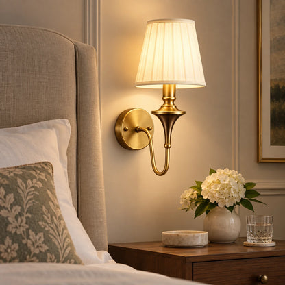 Tapered shade wall sconce beside an upholstered bed