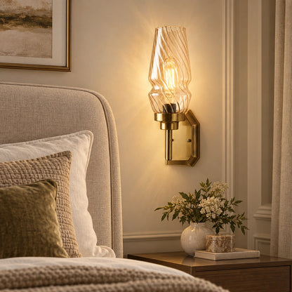 Sculpted ripple-shade wall sconce beside an upholstered bed