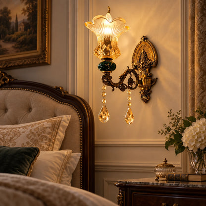 Green and amber floral glass wall sconce beside a bed
