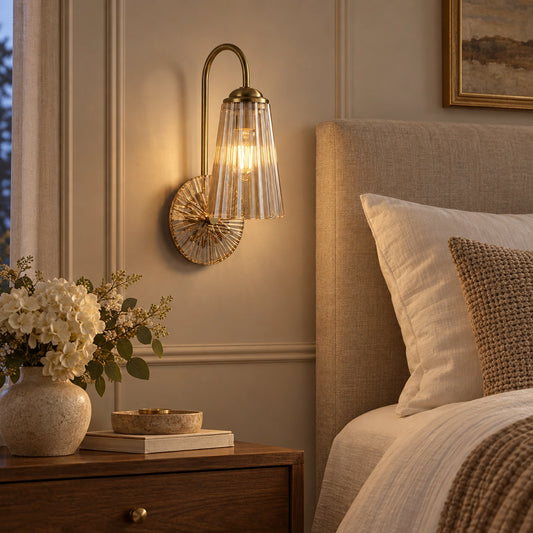 Fluted bell glass wall sconce beside a bed
