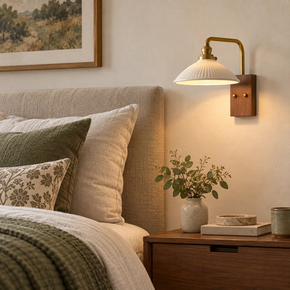 Ceramic dome reading wall sconce beside a bed