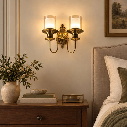 Ornate twin-cylinder wall sconce beside a bed