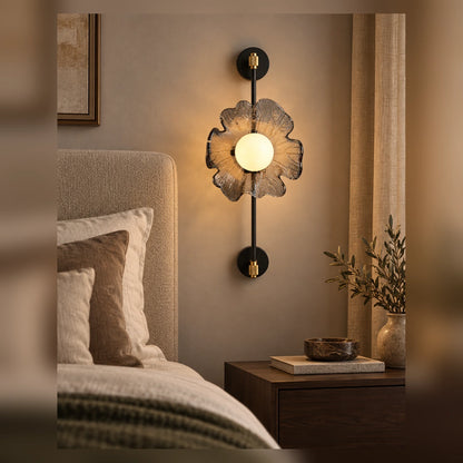 Sculptural flower globe wall light beside an upholstered bed