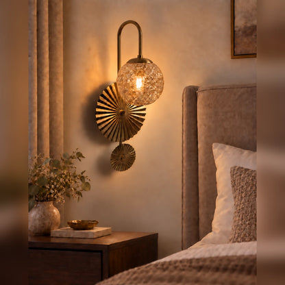 Textured globe fan wall light beside a bed