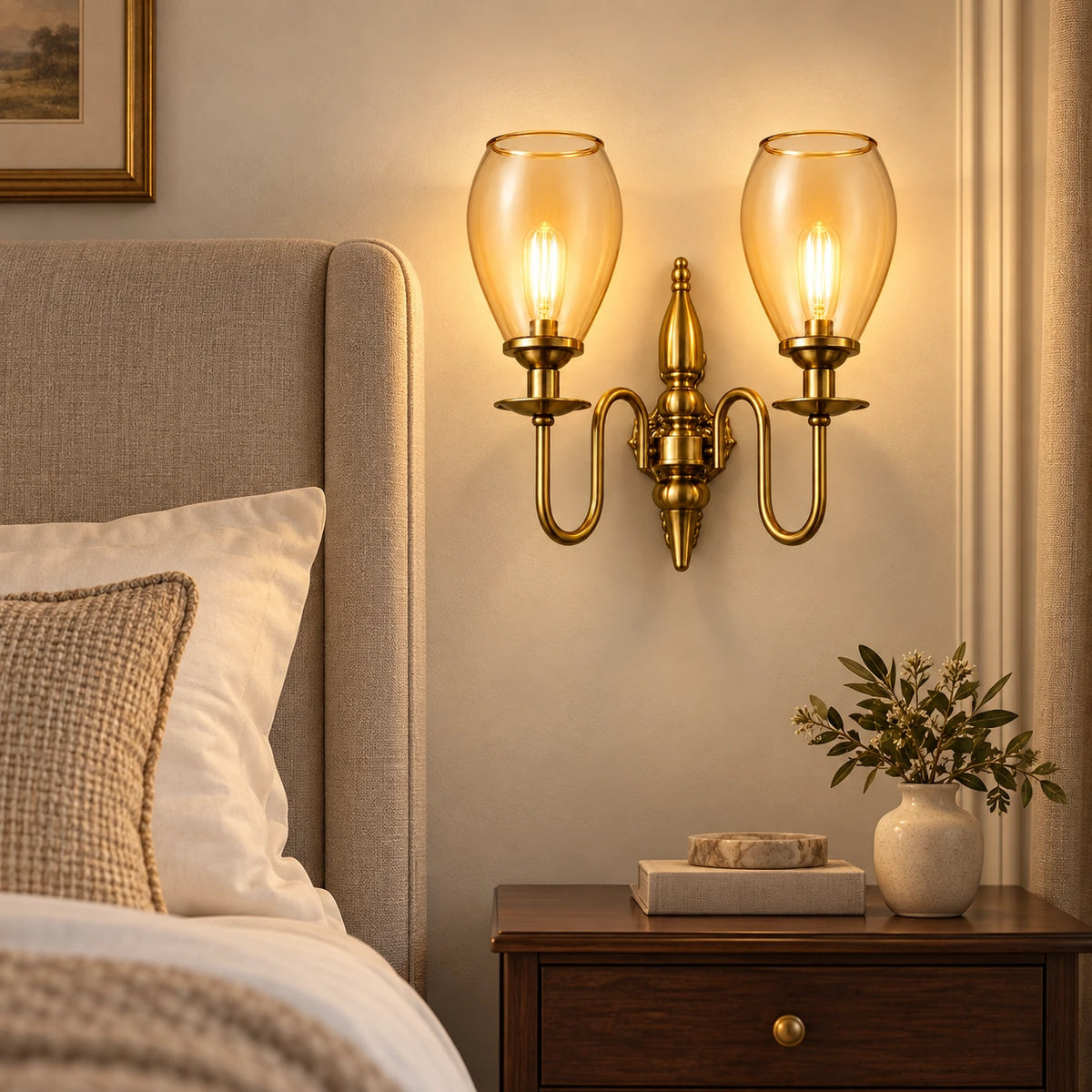 Twin amber tulip-shade wall sconce beside an upholstered bed