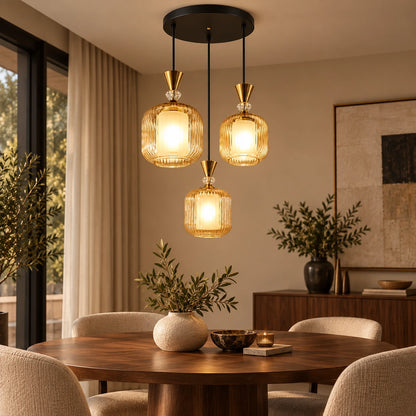 Amber-glass three-light pendant cluster above a dining table