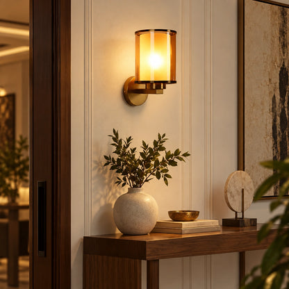 Cylindrical glass wall sconce beside an entrance console
