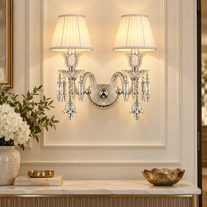 Double-shade crystal wall sconce above an entryway console