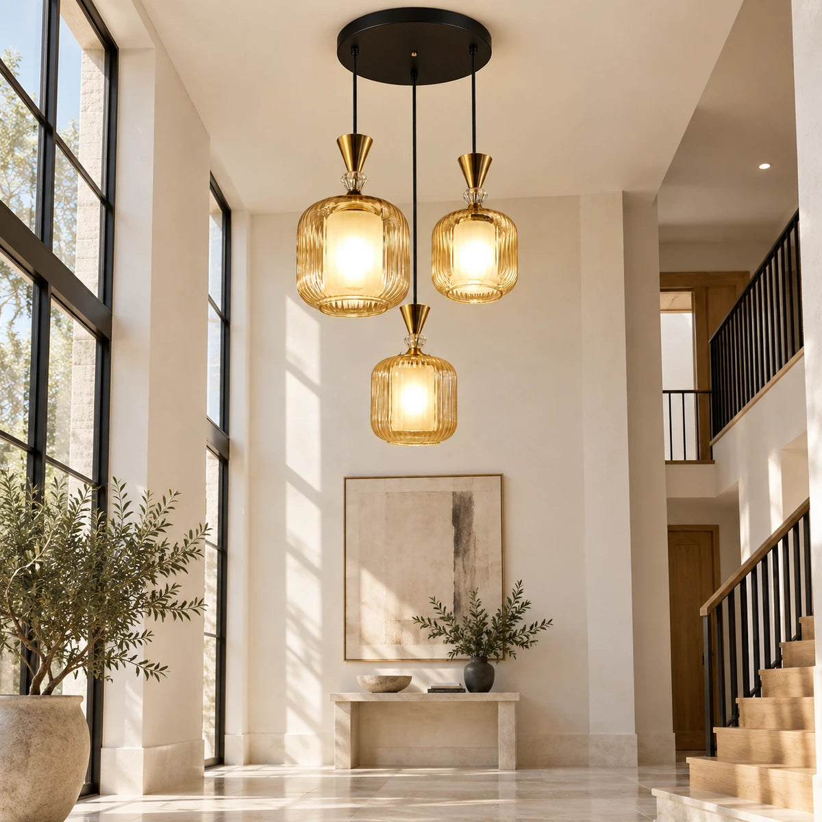 Amber-glass three-light pendant cluster in a double-height foyer