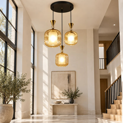 Amber-glass three-light pendant cluster in a double-height foyer