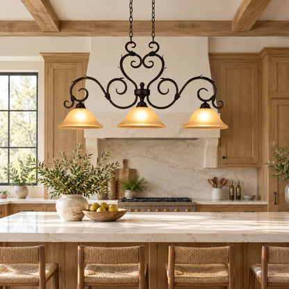 Antique-scroll three-shade linear pendant above a kitchen island