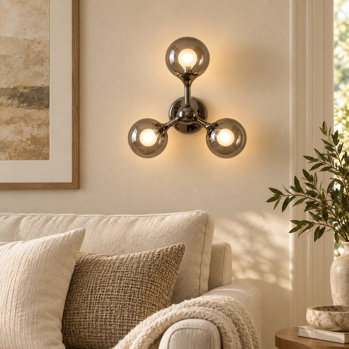 Three-globe smoke-glass wall sconce above living room seating