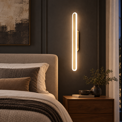 Luma Loop gold and white wall light beside an upholstered bed in a warm hotel-style bedroom