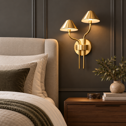 Auric gold and white wall light beside an upholstered bed in a warm hotel-style bedroom