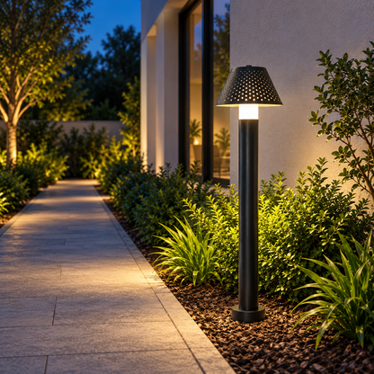Linea matte-black LED bollard light beside a refined garden path at blue hour