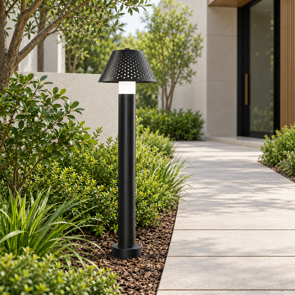 Linea matte-black LED bollard light in a contemporary landscaped courtyard by day