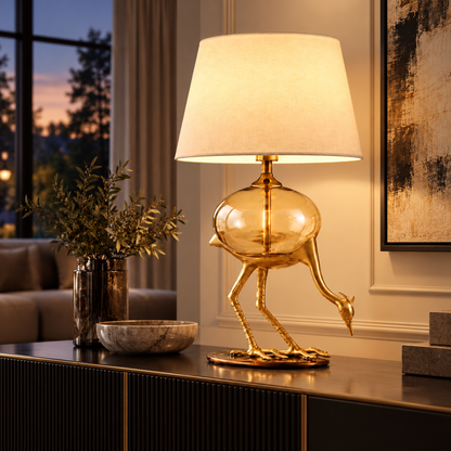 Aurelia gold-tone crane table lamp illuminated on a refined evening console