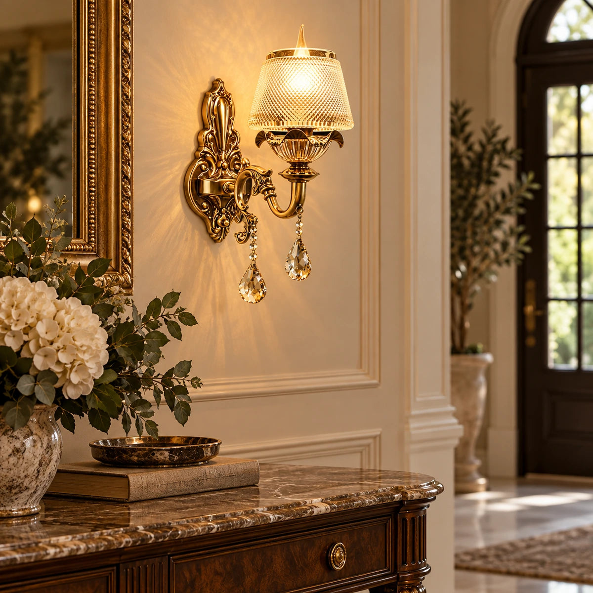 Antique gold crystal wall light beside an entryway console