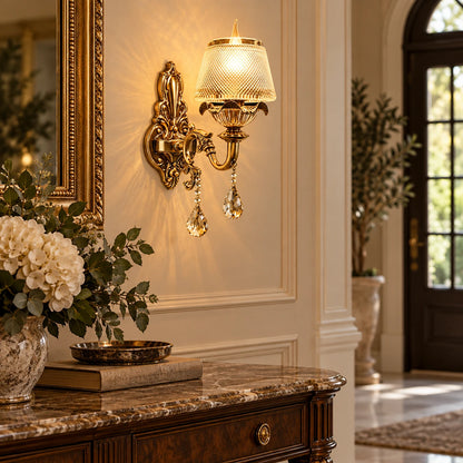 Antique gold crystal wall light beside an entryway console