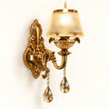Antique gold crystal wall light on a warm-white background