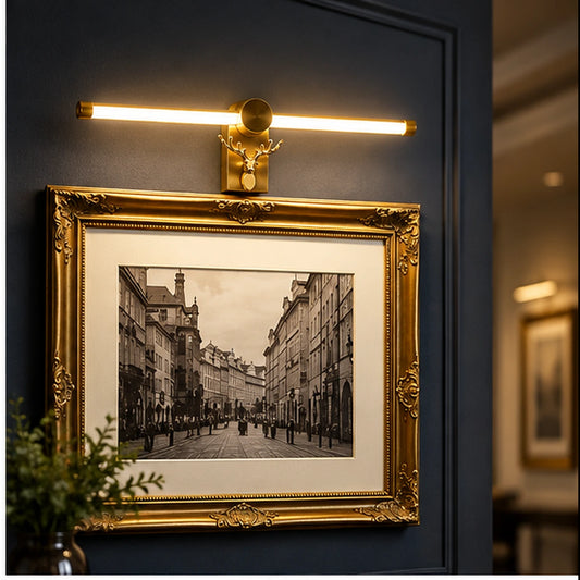Gold picture light above framed artwork