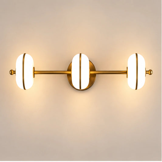 Antique brass three-light vanity bar on warm white