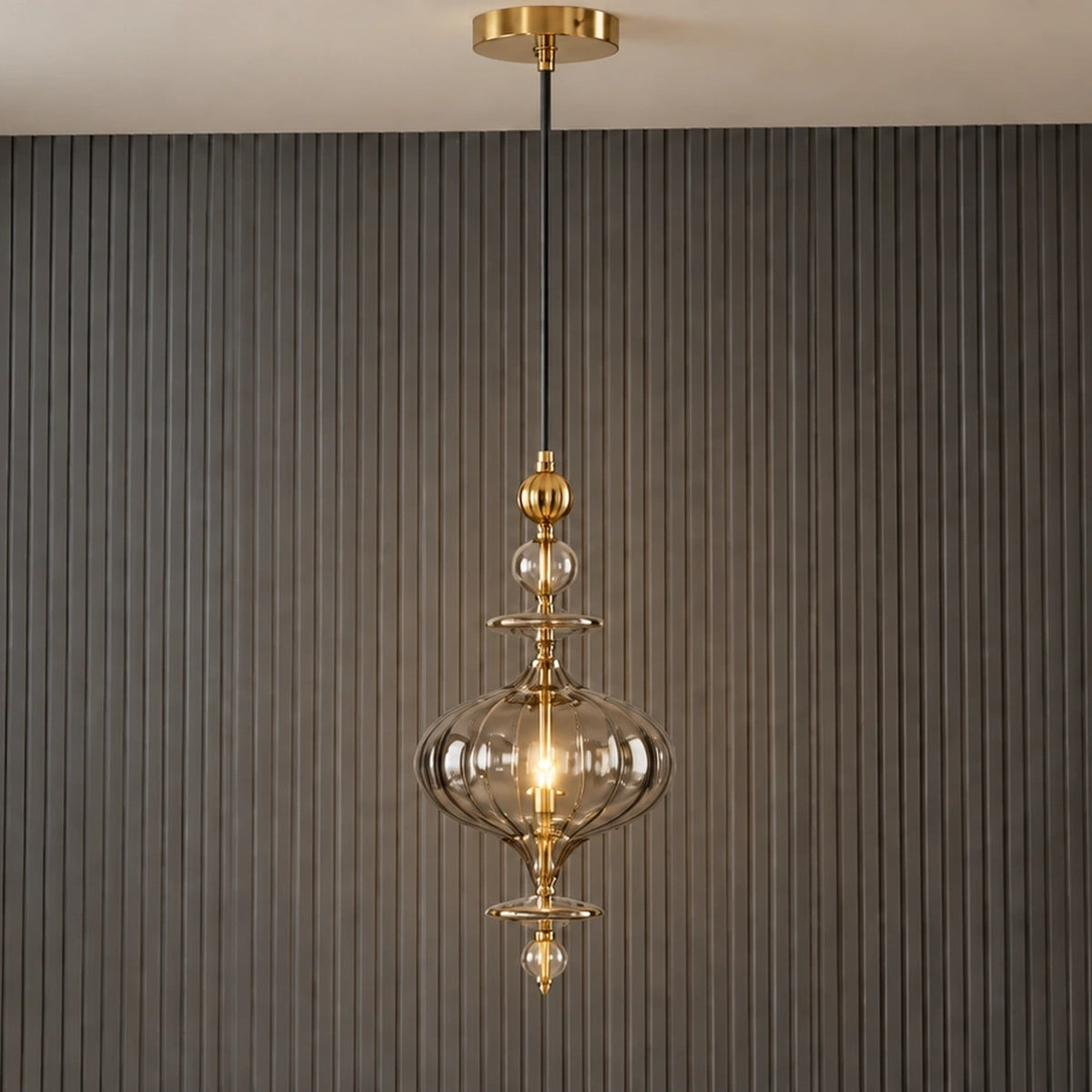 Ornate smoke-glass and gold pendant illuminated in a contemporary room