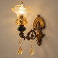 Green and amber floral glass wall sconce on a warm studio wall