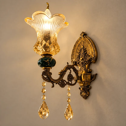 Green and amber floral glass wall sconce on a warm studio wall