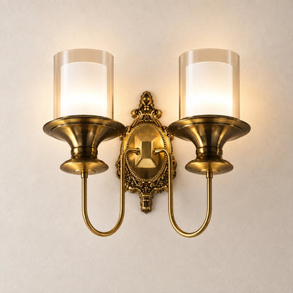 Ornate twin-cylinder wall sconce on a warm studio wall