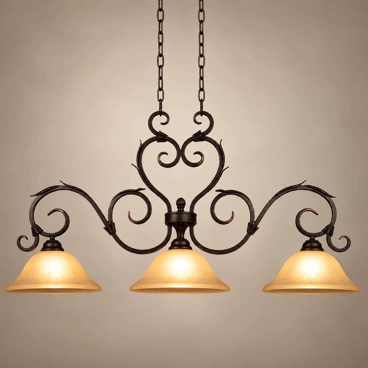 Antique-scroll three-shade linear pendant on a warm studio background