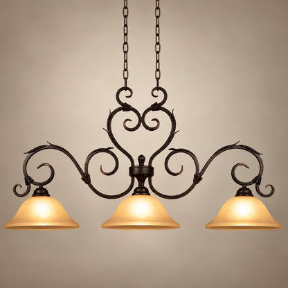 Antique-scroll three-shade linear pendant on a warm studio background
