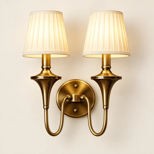 Double arm tapered shade wall sconce with curved brass-tone arm