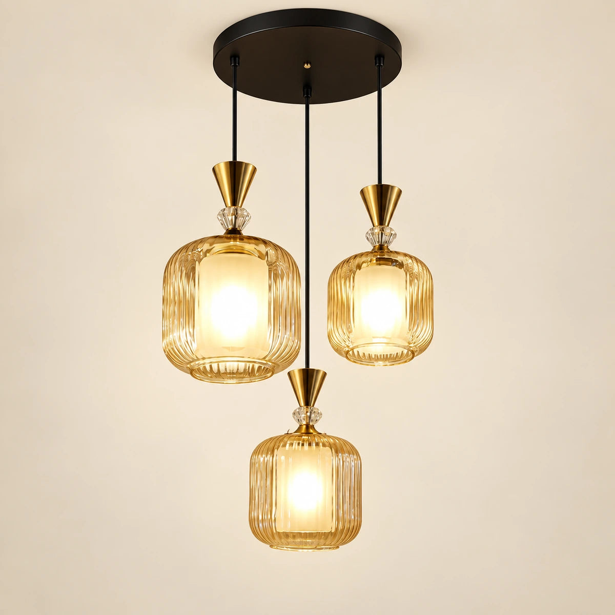 Amber-glass three-light pendant cluster on a warm studio background