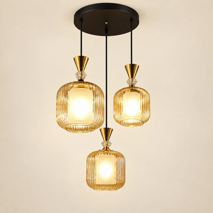Amber-glass three-light pendant cluster on a warm studio background