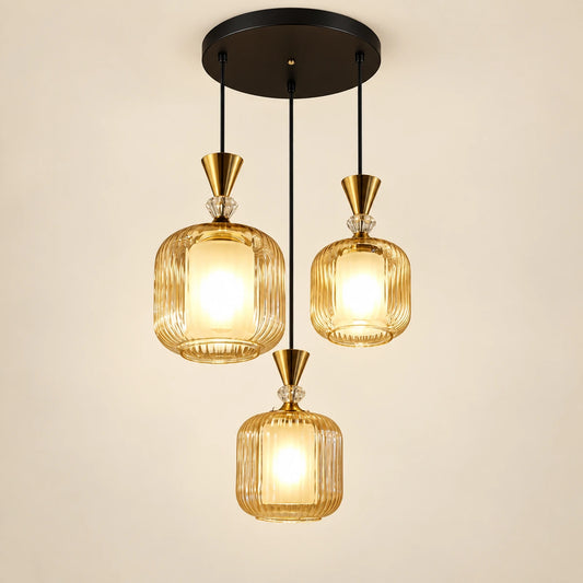 Amber-glass three-light pendant cluster on a warm studio background