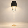 Three-arm shaded floor lamp on a warm studio background