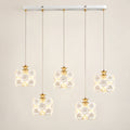 Floral ceramic five-shade pendant cluster on a warm studio background