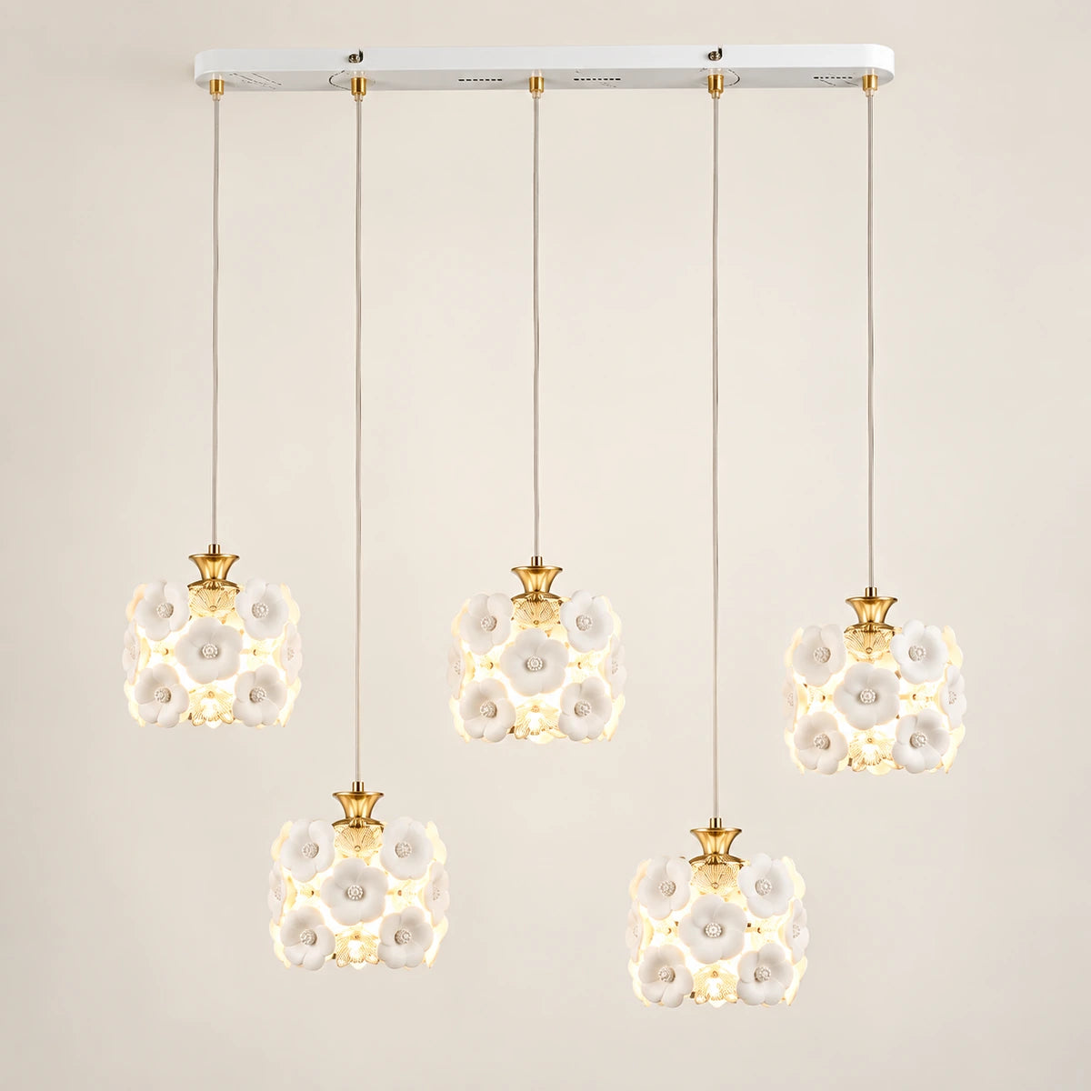 Floral ceramic five-shade pendant cluster on a warm studio background
