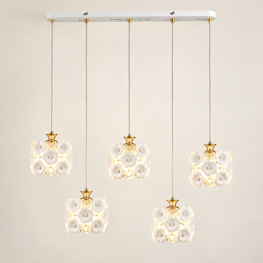 Floral ceramic five-shade pendant cluster on a warm studio background