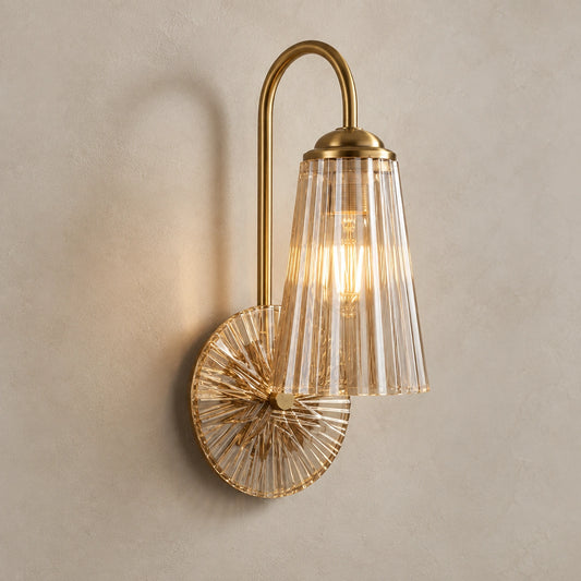 Fluted bell glass wall sconce on a warm studio wall