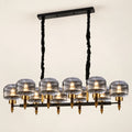 Smoke-glass ten-light linear pendant on a warm studio background