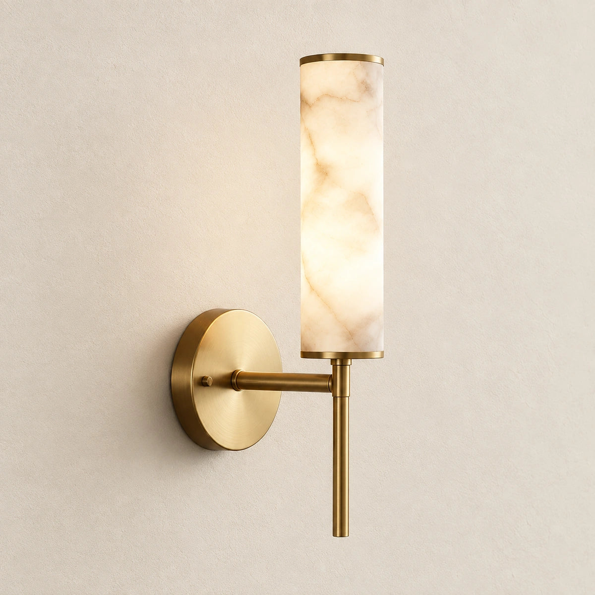 Alabaster-look cylinder wall sconce on a warm studio wall