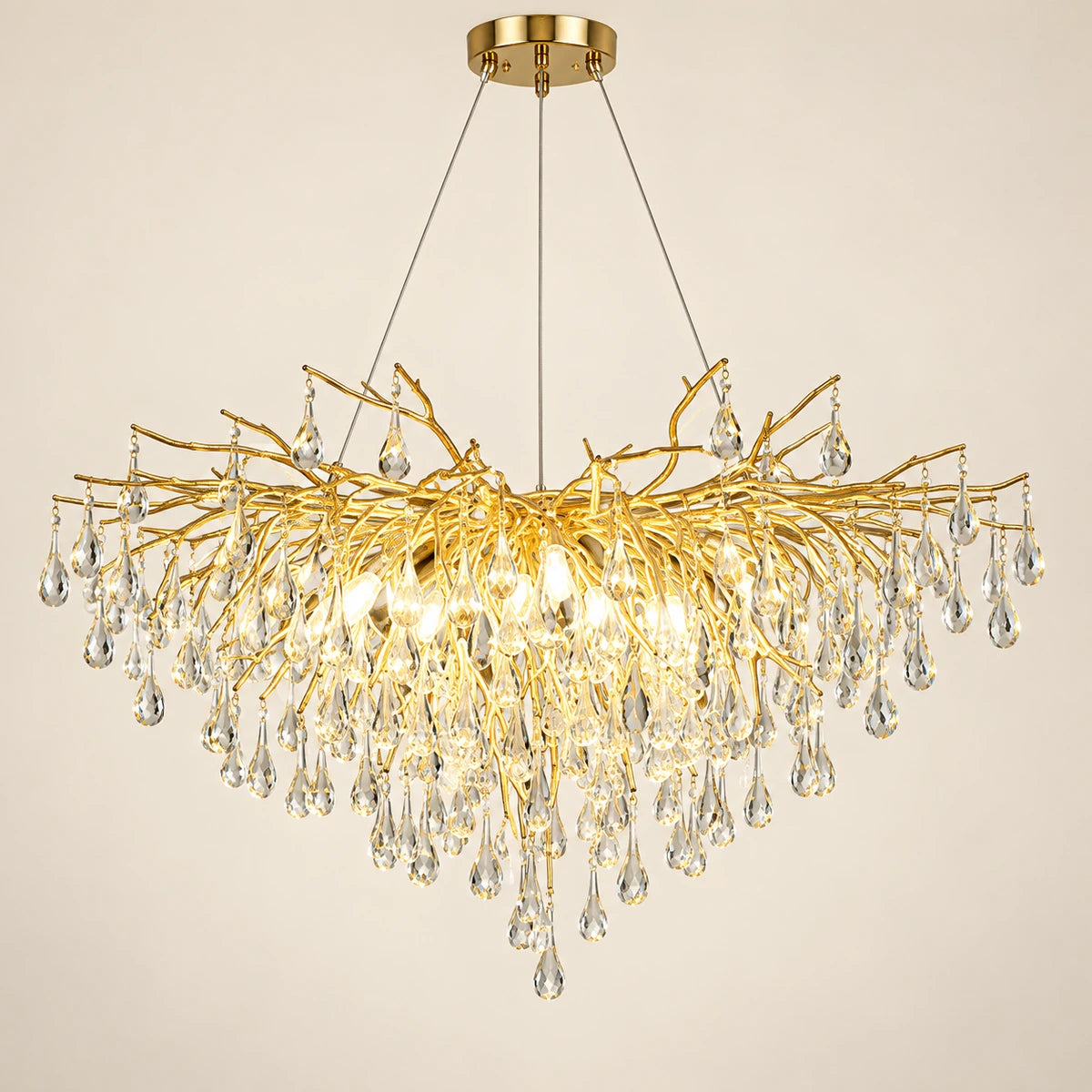 Gold branch crystal chandelier on a warm studio background
