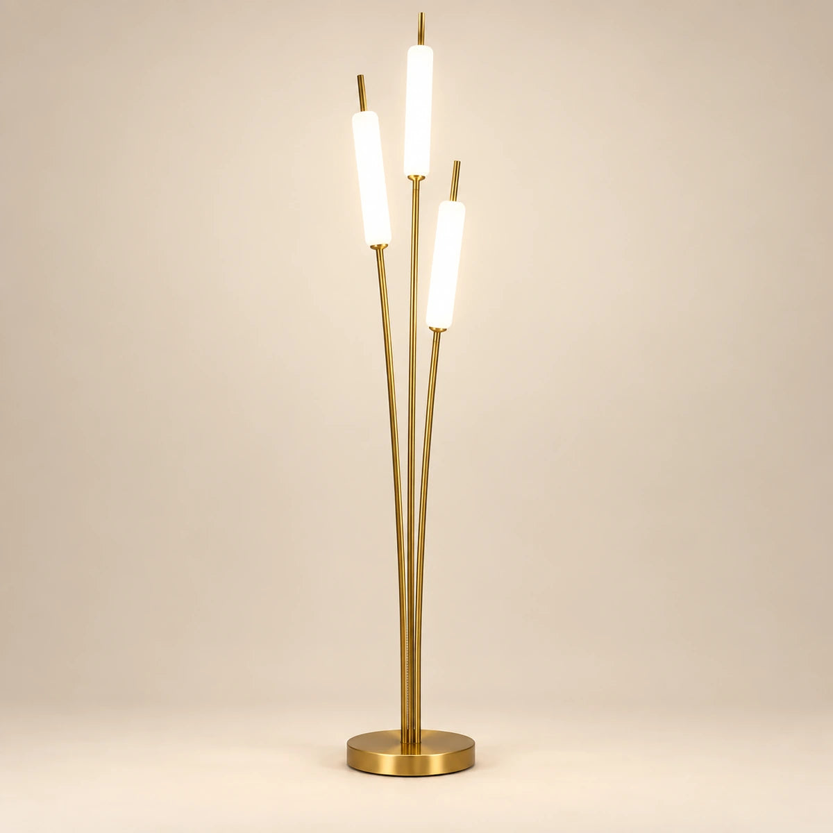 Gold-tone floor lamp with three staggered glowing white tubes